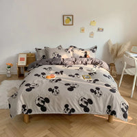 Ensemble Housse de Couette Ado avec Imprimé de Mickey Mouse installée sur un lit avec un bureau et une chaise à droite et une petite étagère à gauche