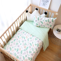 Ensemble Housse de Couette Bebe avec Imprimé en Forme de Feuille installée dans un lit pour bébé avec deux coussin