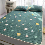 Ensemble Surmatelas avec Motif Floral installé sur un lit avec deux coussin et un meuble à gauche