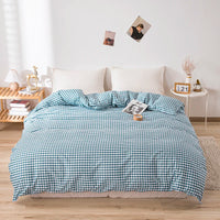 Housse de Couette Bleue avec Motif à Carreaux sur un lit avec une table de nuit à droite et une petite étagère à gauche