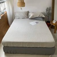 Housse de Matelas Grise et Douce en Lin, sur un lit.