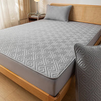 Surmatelas Doux Confortable et Imperméable, sur un lit, de couleur gris.